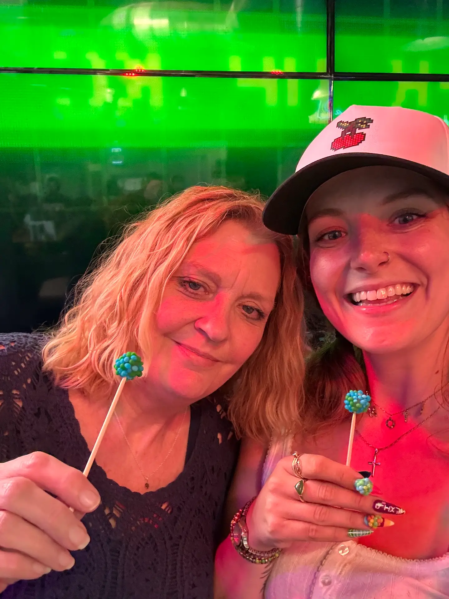 Woman holding a tray of colorful candy samples with toothpicks at a Pixlz branded booth.