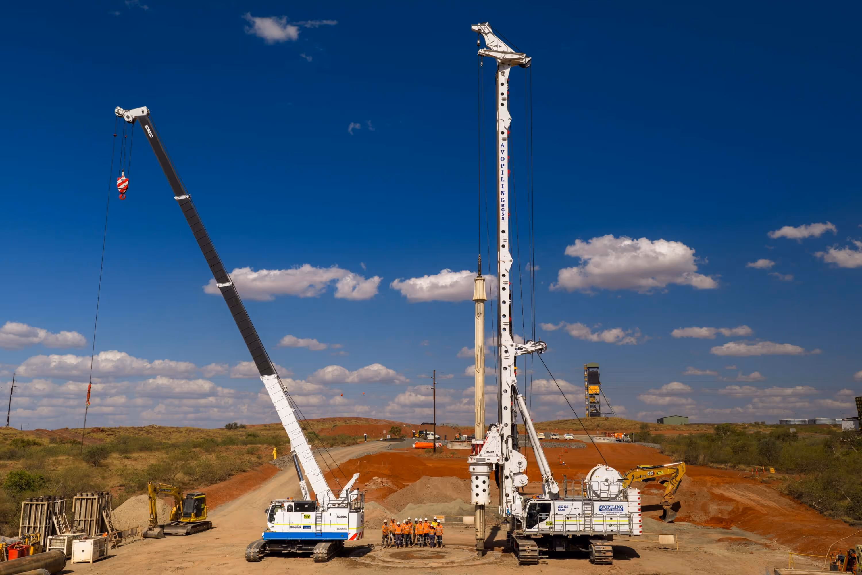 Large industrial warehouse filled with heavy machinery, equipment, tools, and metal parts organized along the floor and shelves.