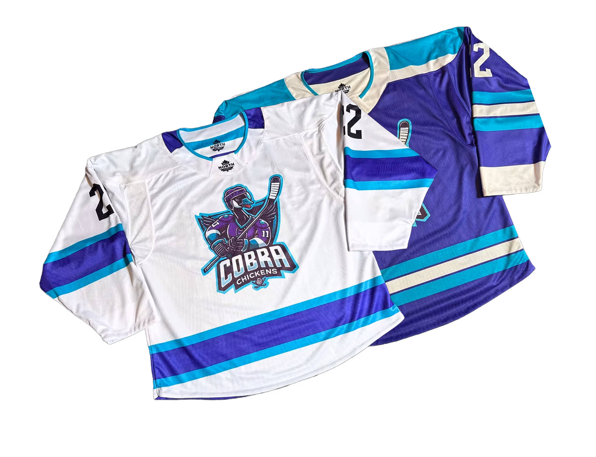 Two hockey jerseys, one white and one purple, with teal and blue stripes and a logo of a hockey-playing chicken with the text 'Cobra Chickens'.