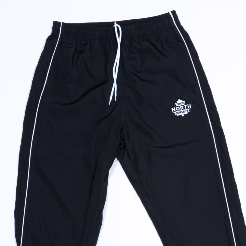 Black athletic pants with white side stripes and a white drawstring, featuring a 'True North Jerseys' logo on the right thigh.