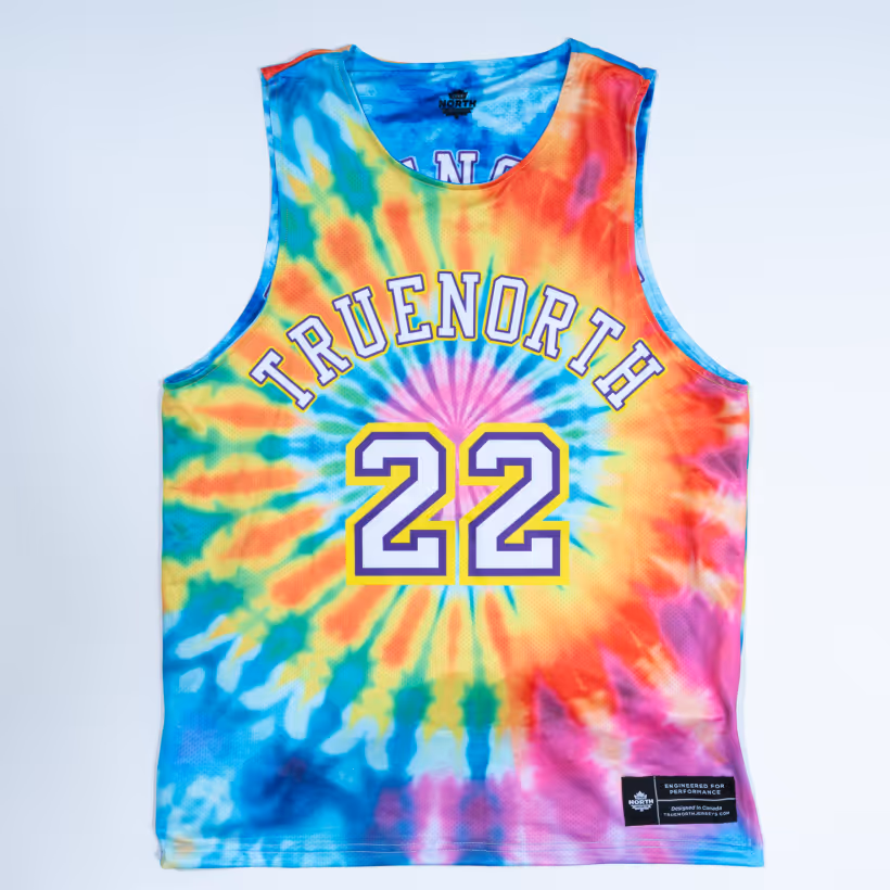 Sleeveless tie-dye basketball jersey with the word TRUENORTH and the number 22 in white and purple on the front.