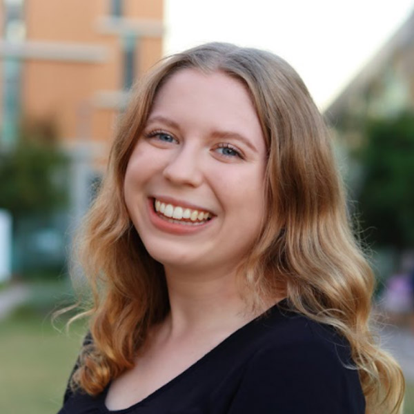 Headshot of Alissa Bombardier Shaw smiling outdoors with a soft-focus background.