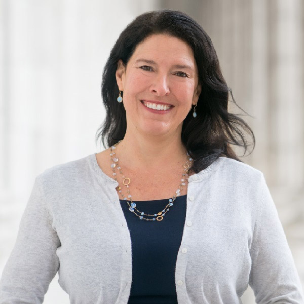 Headshot of Susannah Wellford smiling, wearing a light cardigan and layered necklace.