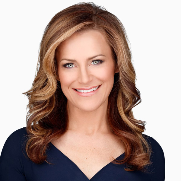 Headshot of Amber McReynolds smiling in a navy top against a light background.