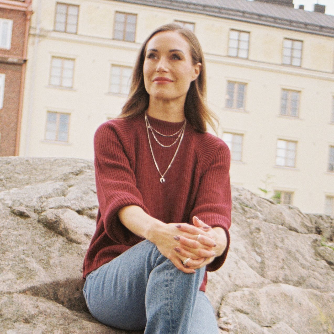 A woman sitting on a rock.
