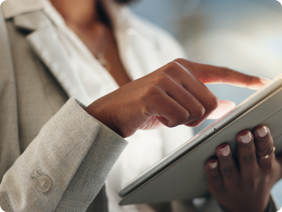 Close-up of a person wearing a light gray suit interacting with a tablet device.