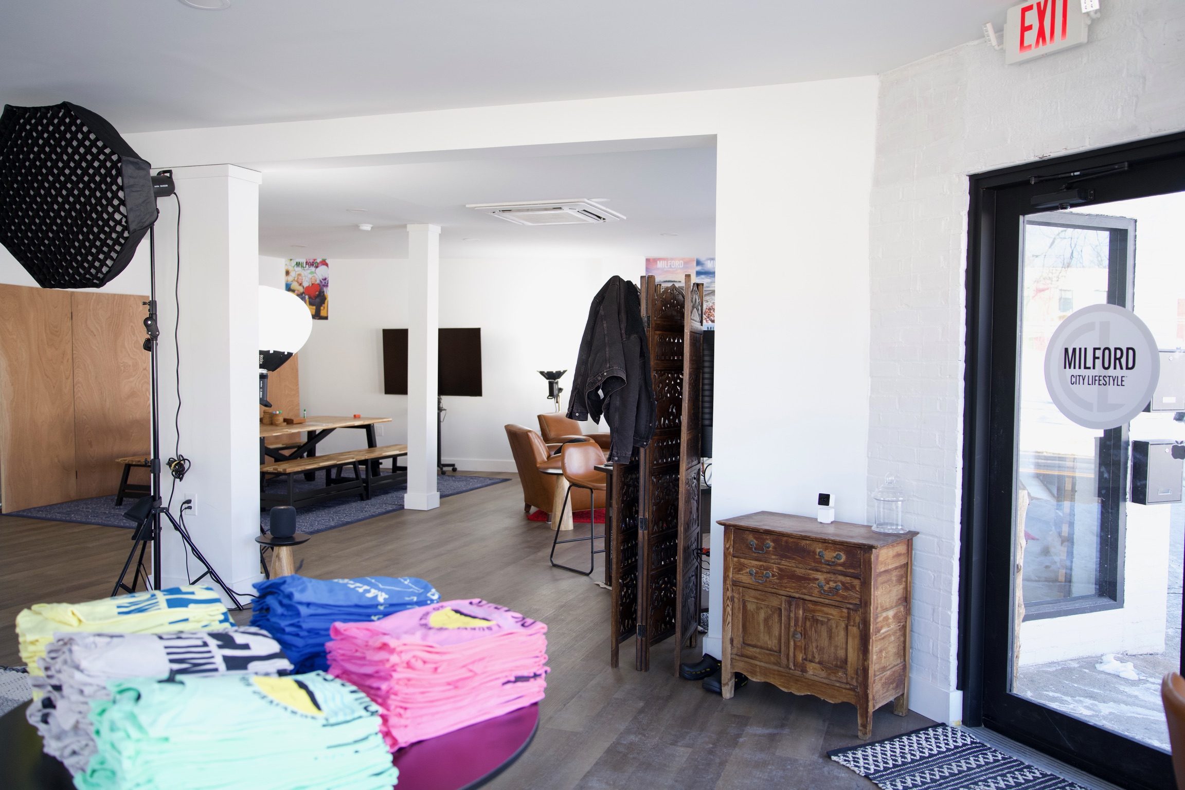 a creative studio space in downtown Milford with computers, TVs, chairs, tables, photo equipment, etc.