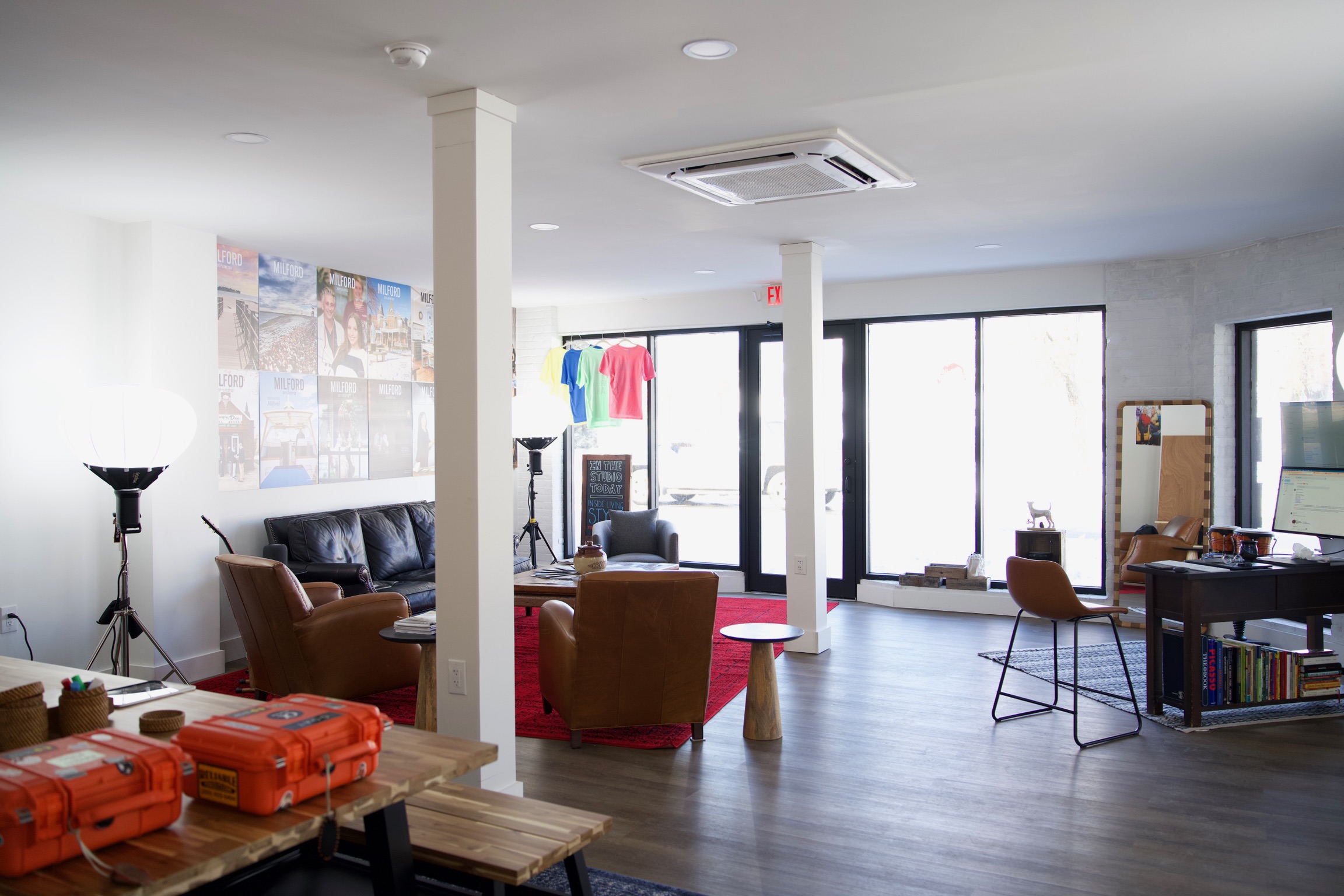 a creative studio space in downtown Milford with computers, TVs, chairs, tables, photo equipment, etc.