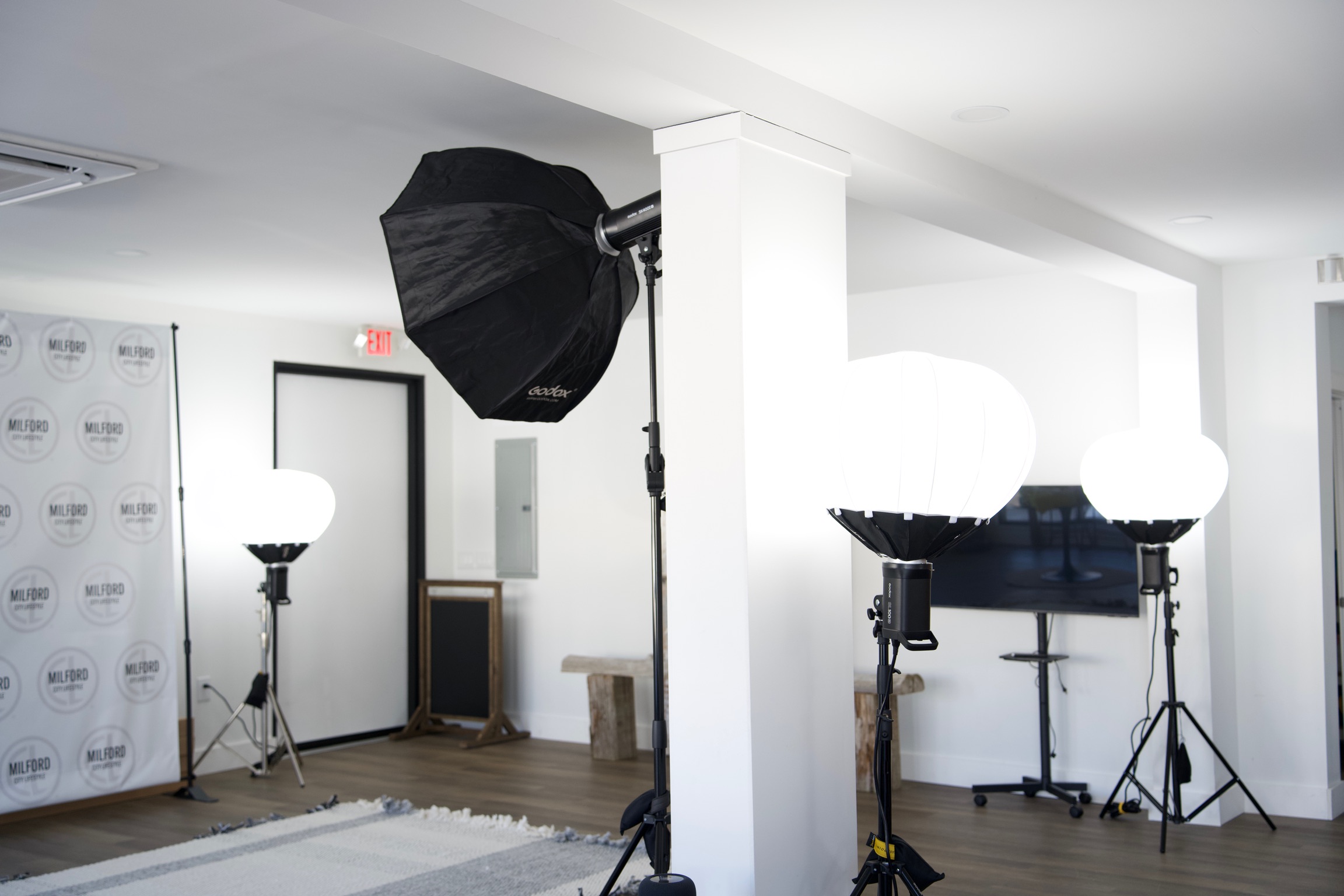 a creative studio space in downtown Milford with computers, TVs, chairs, tables, photo equipment, etc.