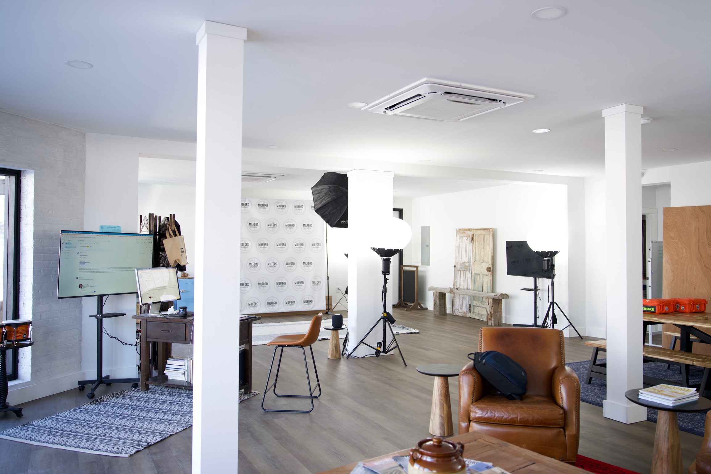 a creative studio space in downtown Milford with computers, TVs, chairs, tables, photo equipment, etc.