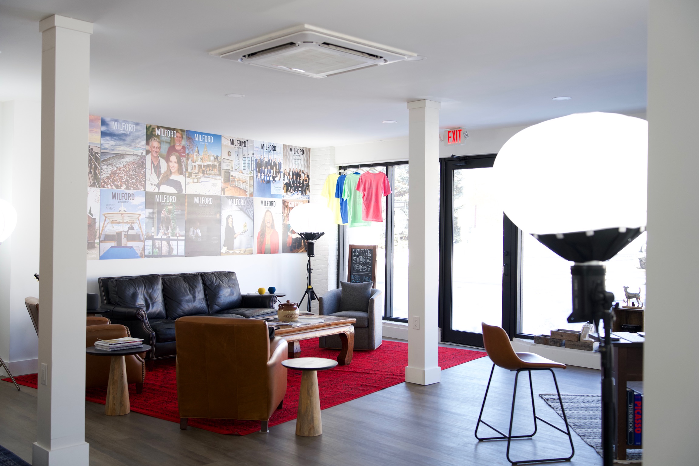 a creative studio space in downtown Milford with computers, TVs, chairs, tables, photo equipment, etc.