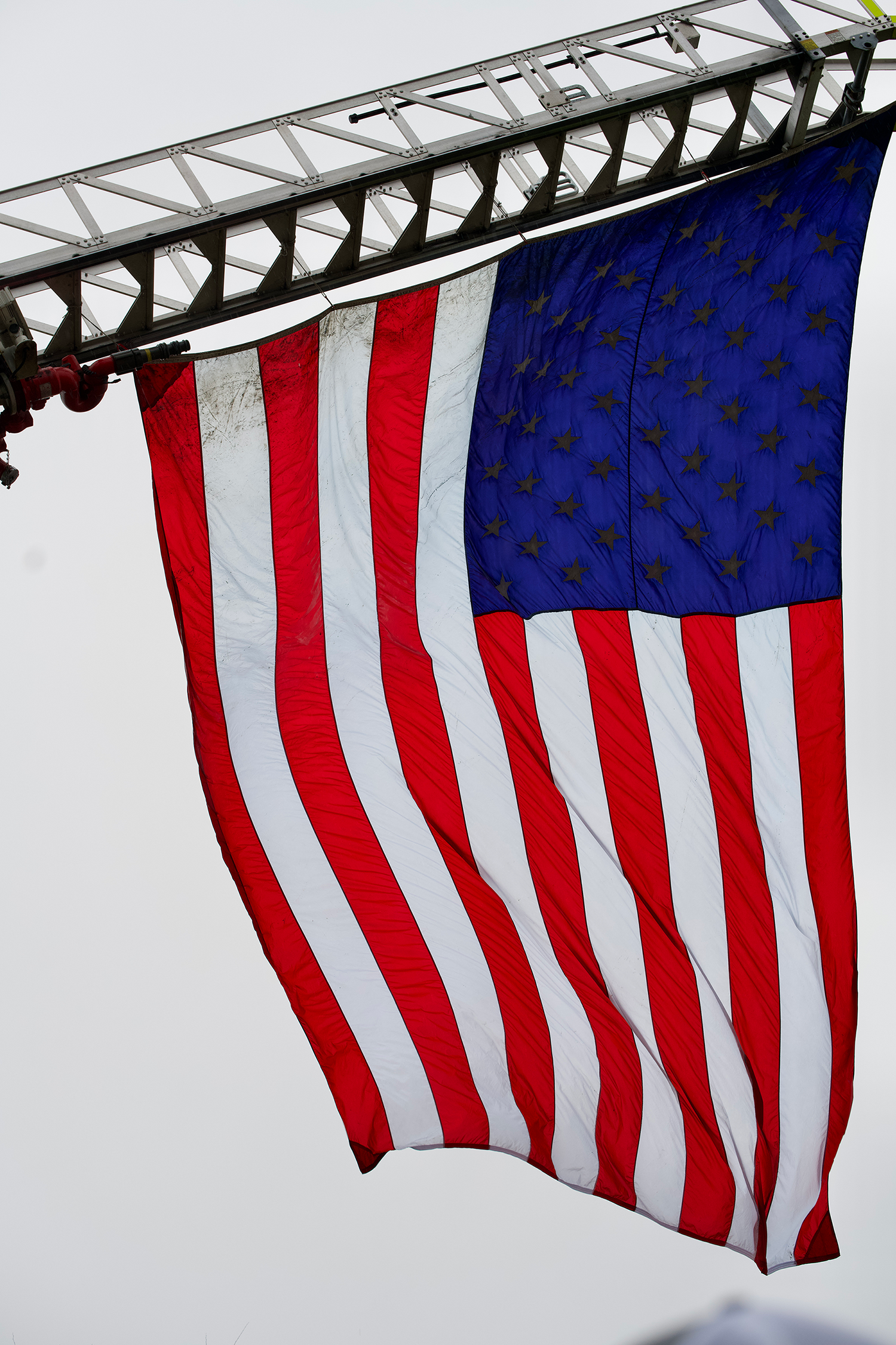 the American flag flying on a fire truck's ladder