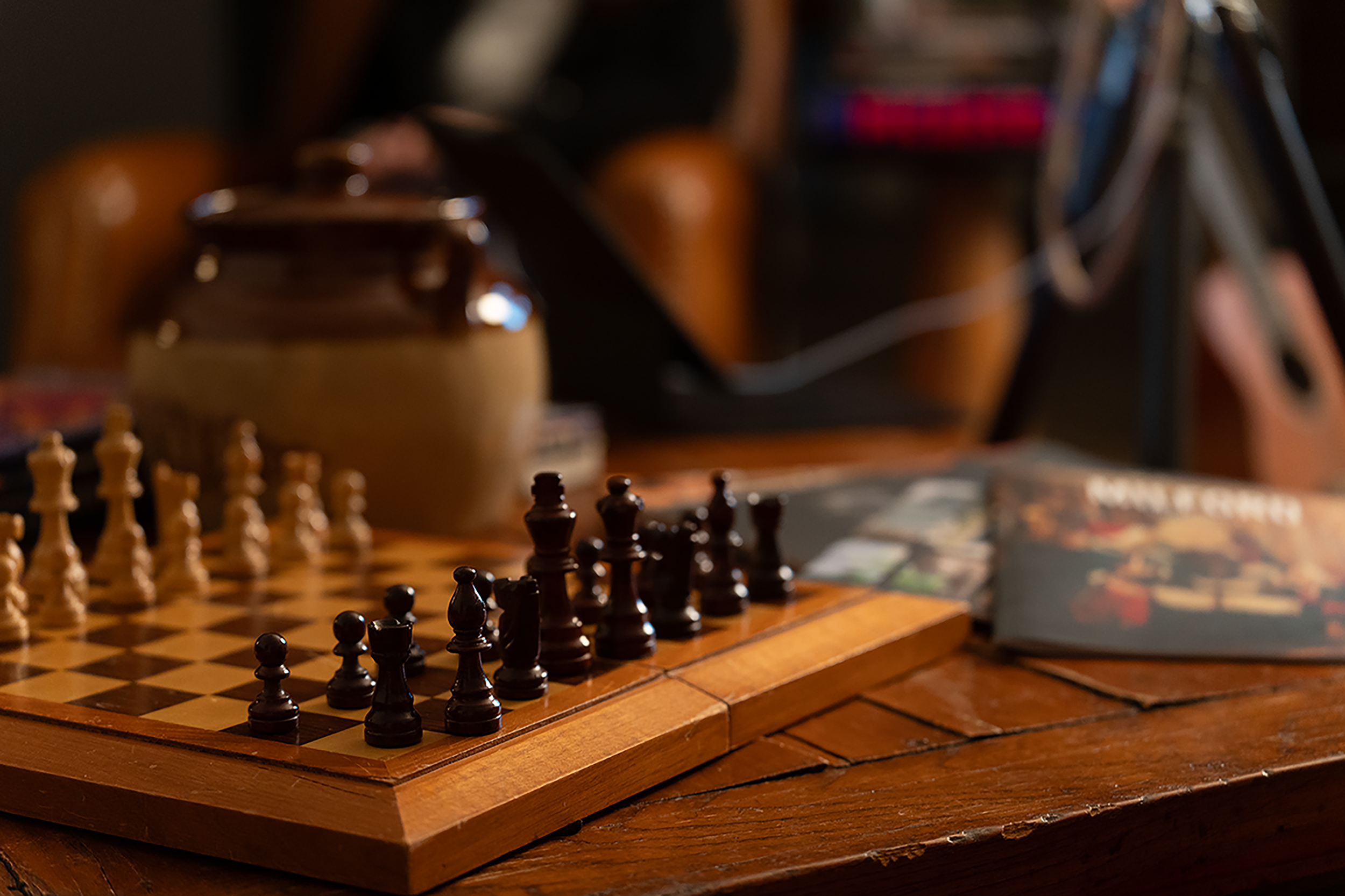 a photo of a chess board in focus on a table with everything else out of focus