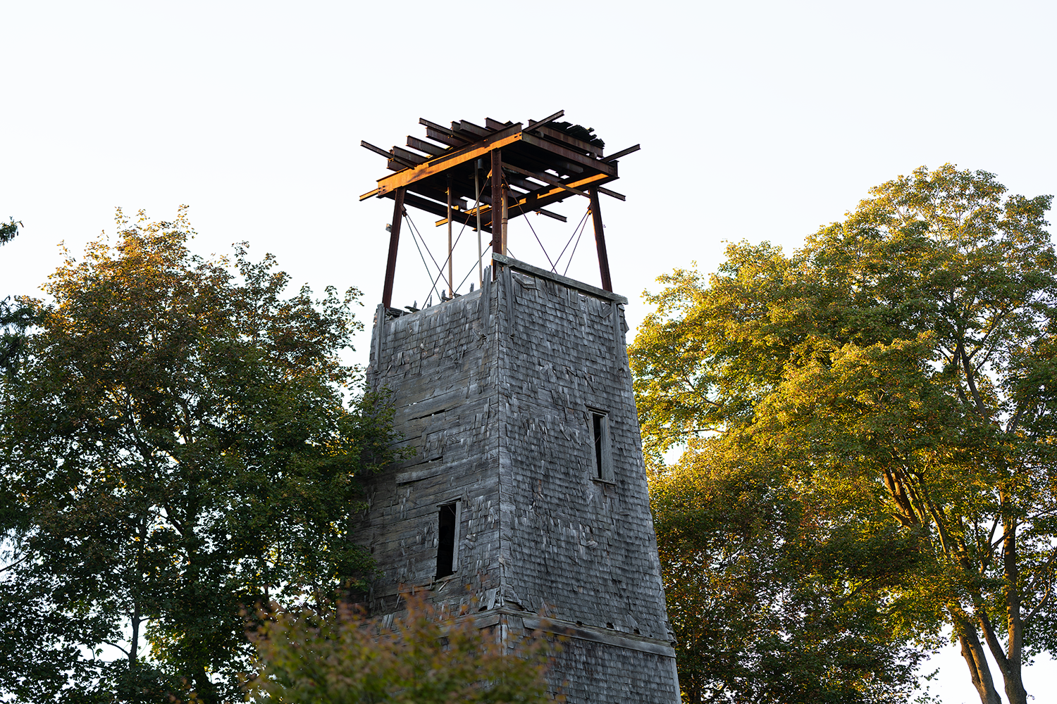 a tall stone tower with trees on both sides