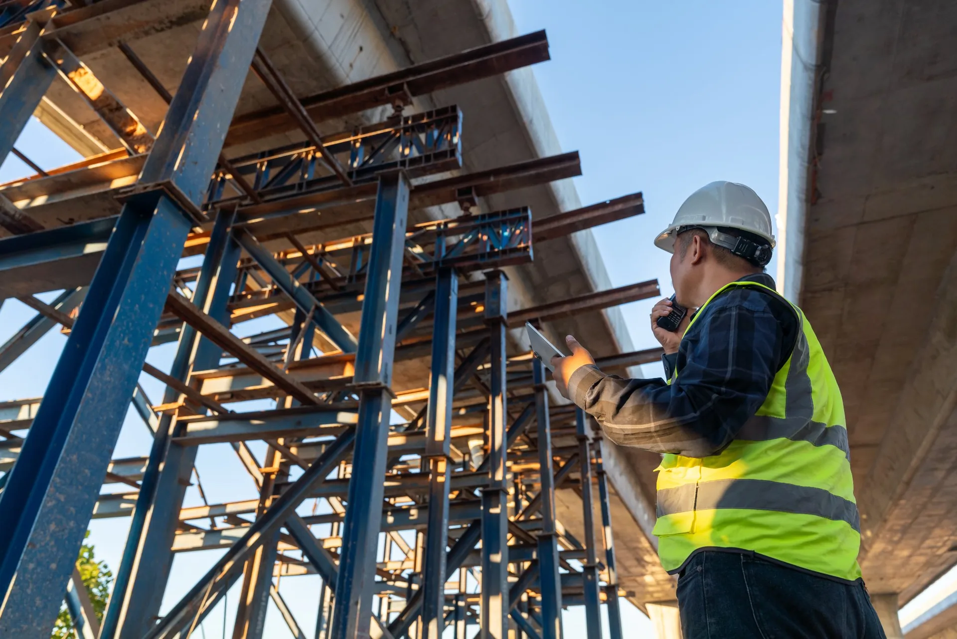 Man in hard hat watching over building site Construction Management