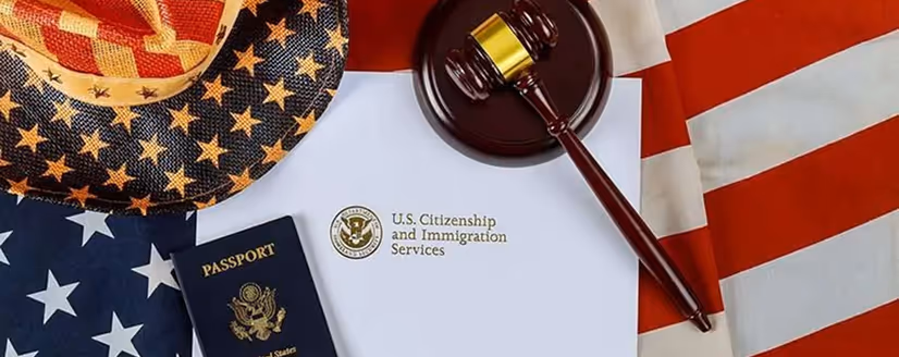 U.S. Citizenship and Immigration Services envelope, a U.S. passport, a gavel, and an American flag-patterned hat and fabric.