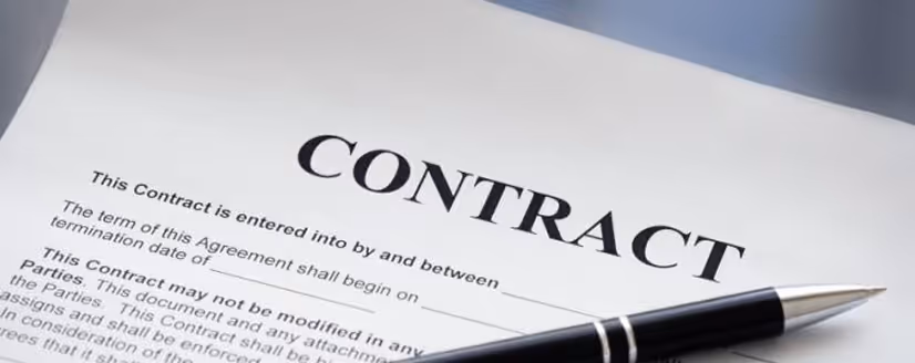 Close-up of a contract document with a black and silver pen resting on top.