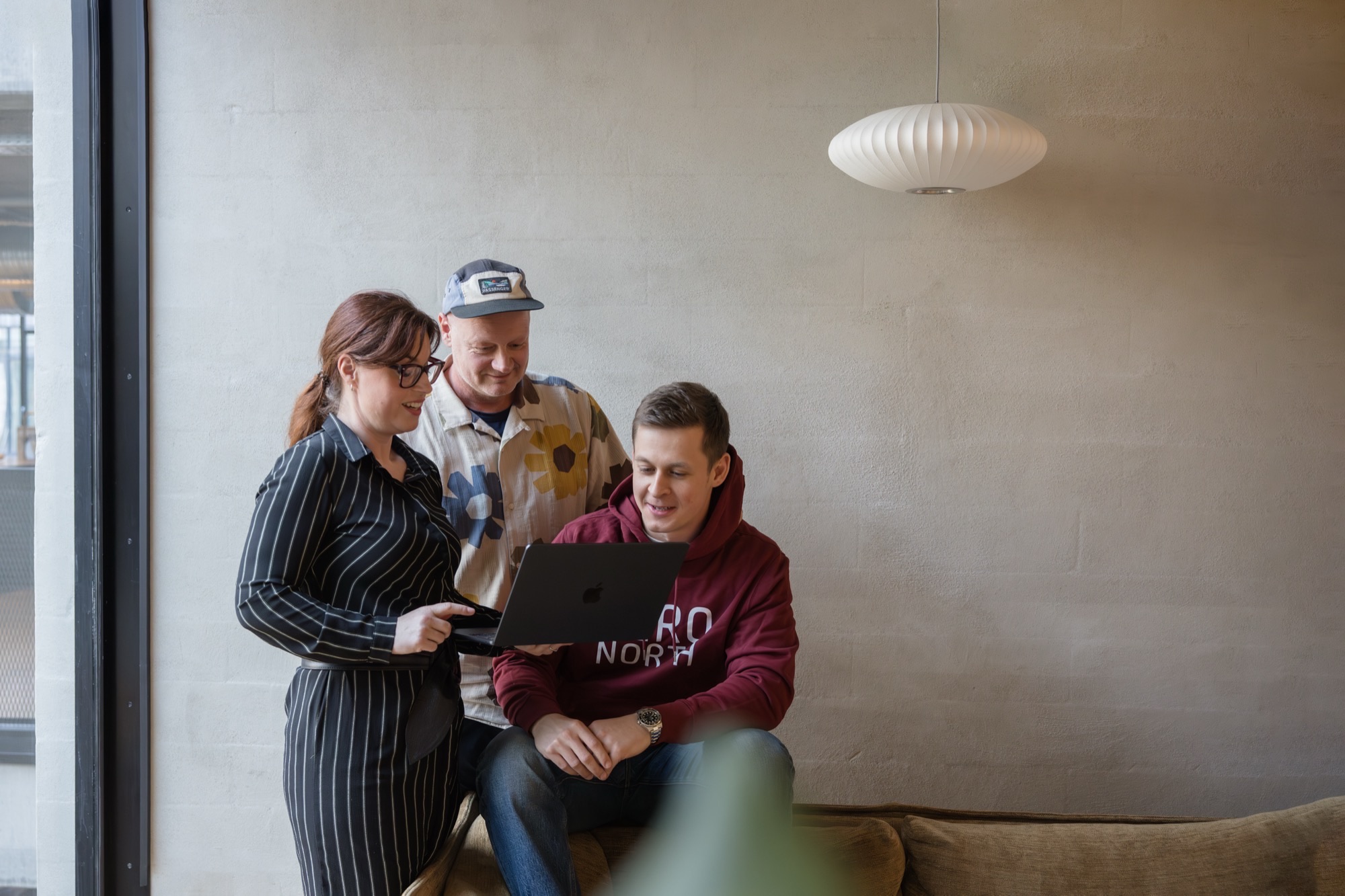 ZeroNorth team members reviewing work on a laptop at the Copenhagen office