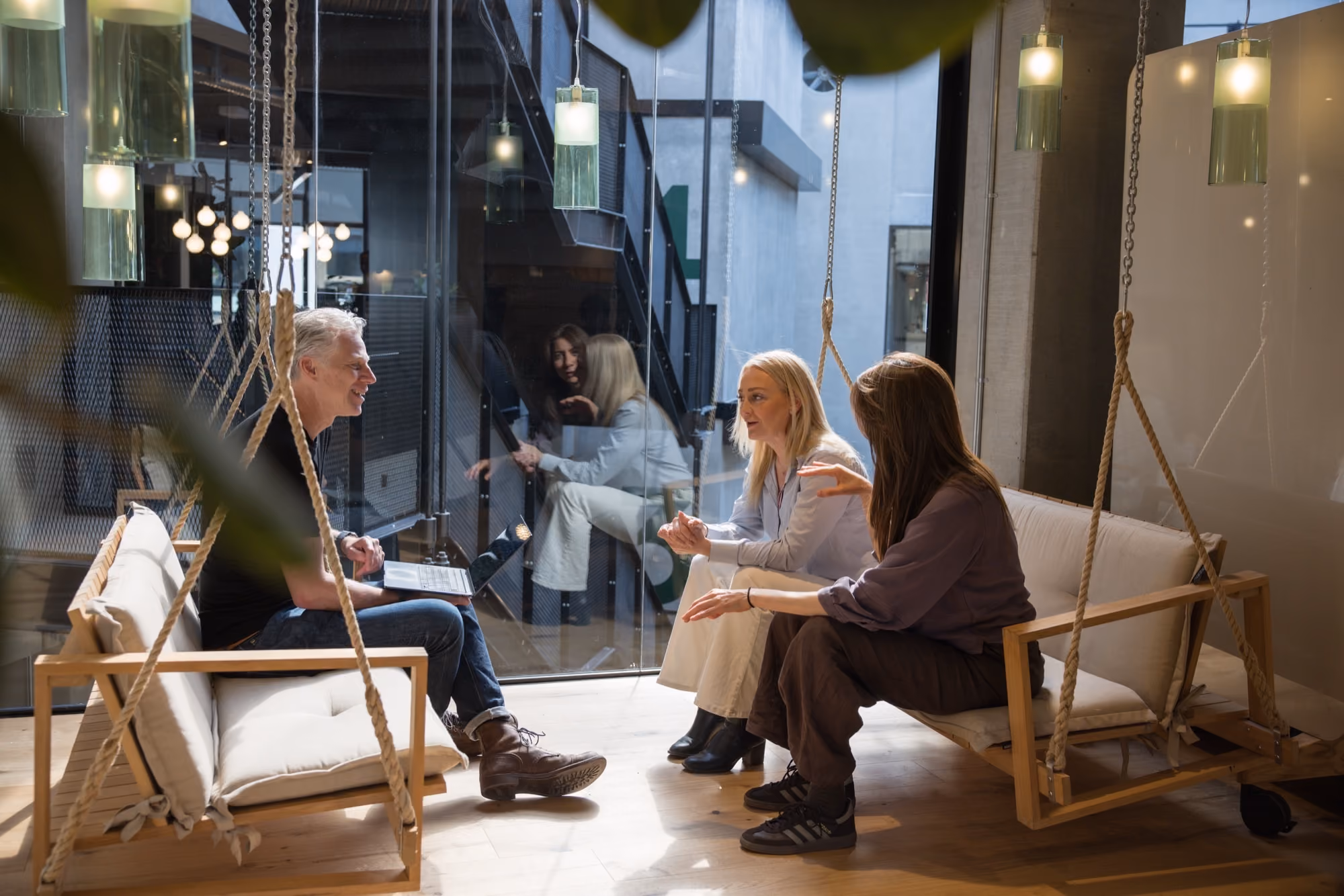 Colleagues in conversation on the swing seats at the ZeroNorth Copenhagen office