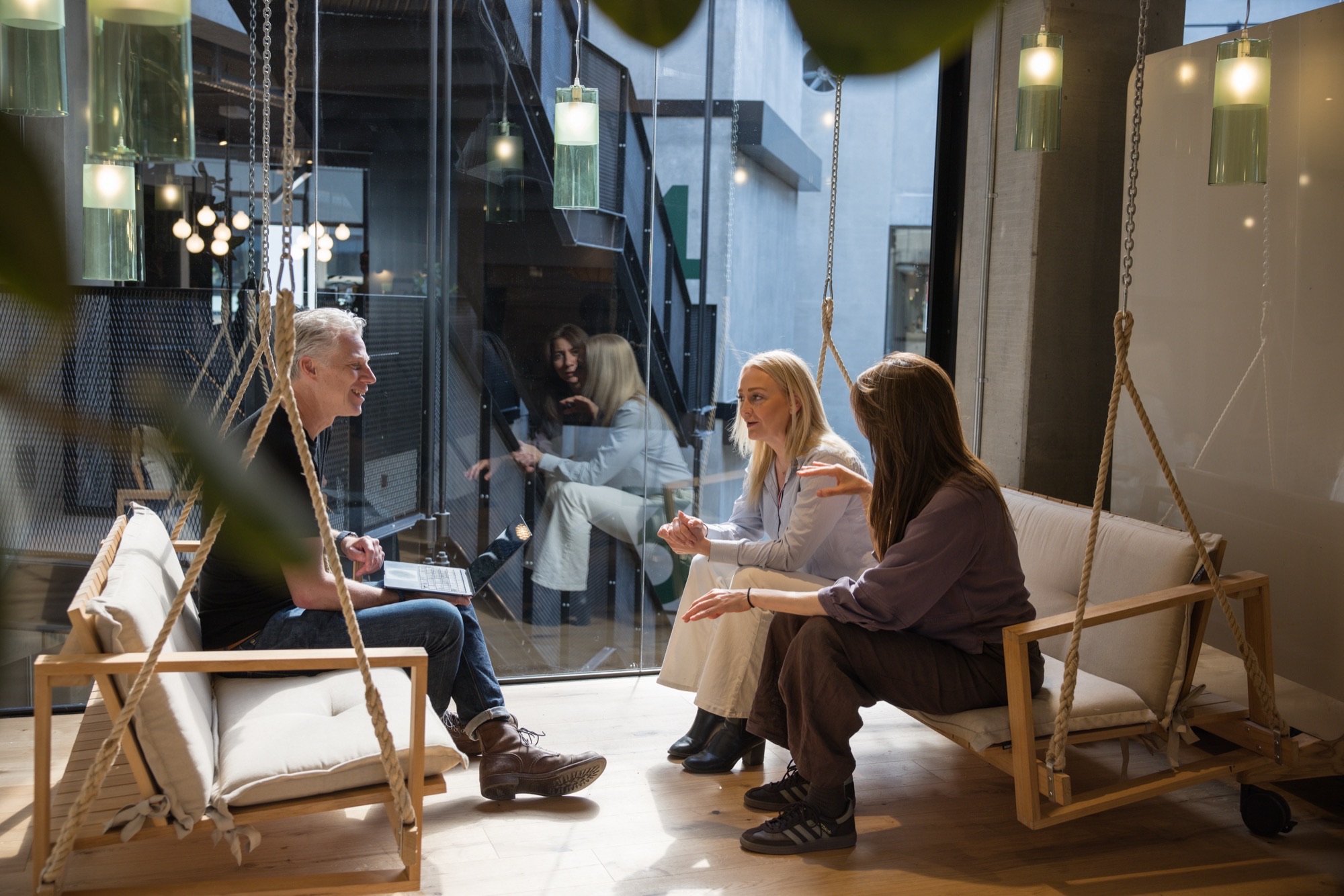 Colleagues in conversation on the swing seats at the ZeroNorth Copenhagen office