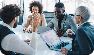 Four diverse colleagues engaged in a lively business meeting around a table with laptops and charts.