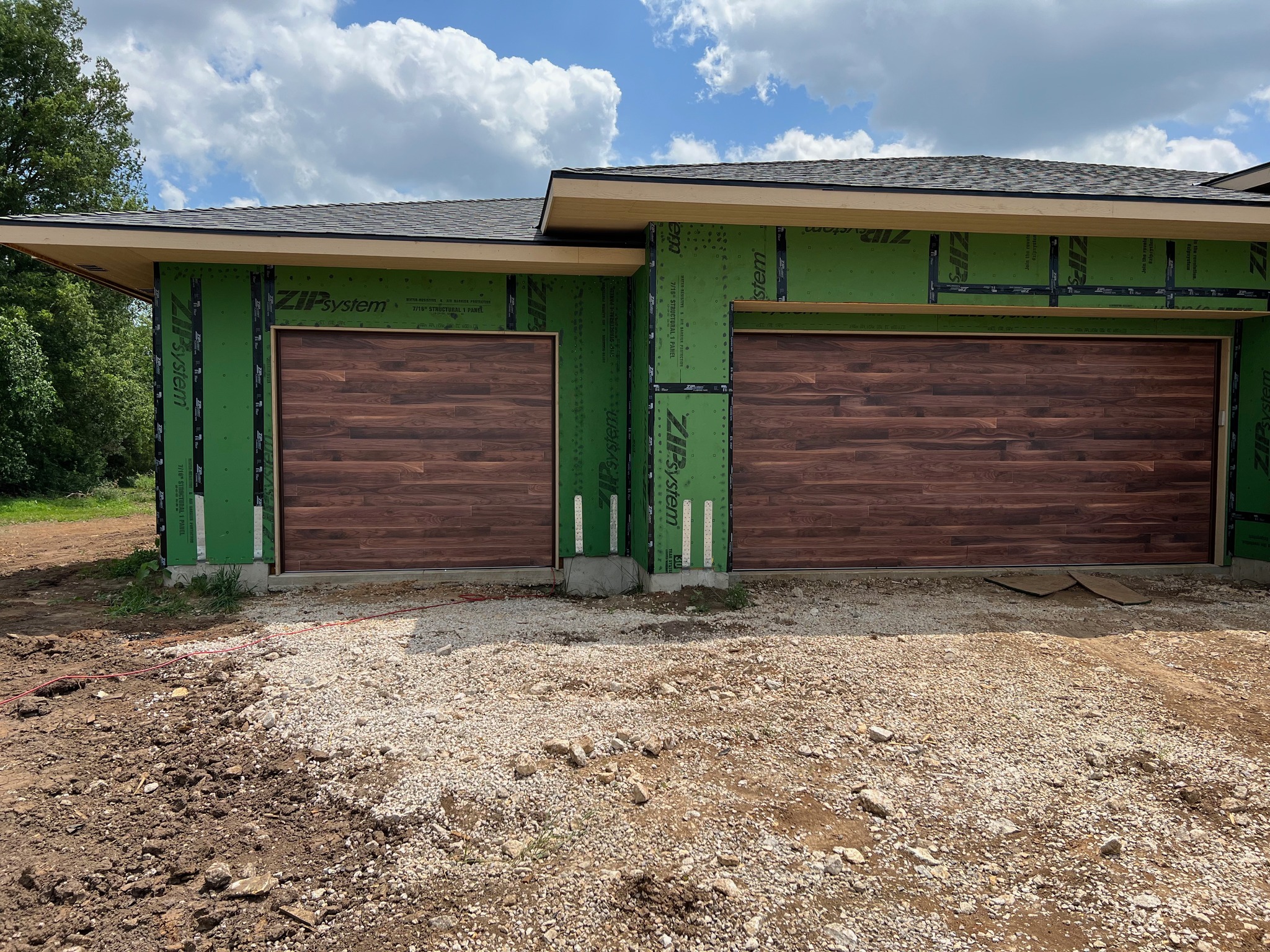 Exterior view of two newly installed DoorLink 3700 garage doors in walnut. 