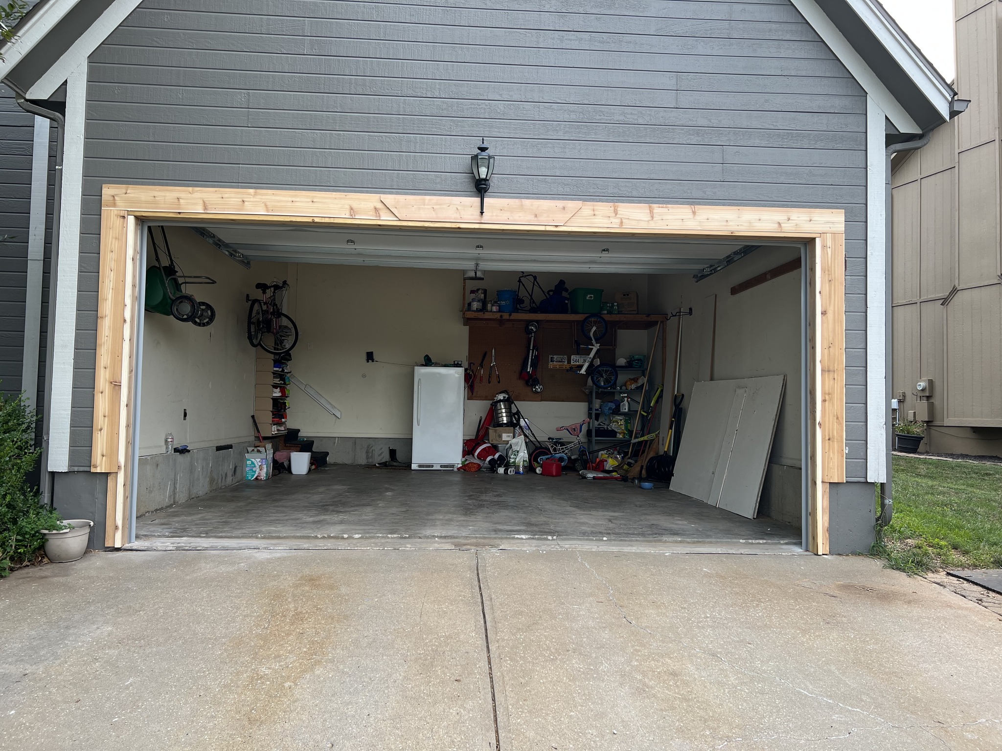Open two-car garage with gray exterior siding. Photo shows completed garage wall framing.