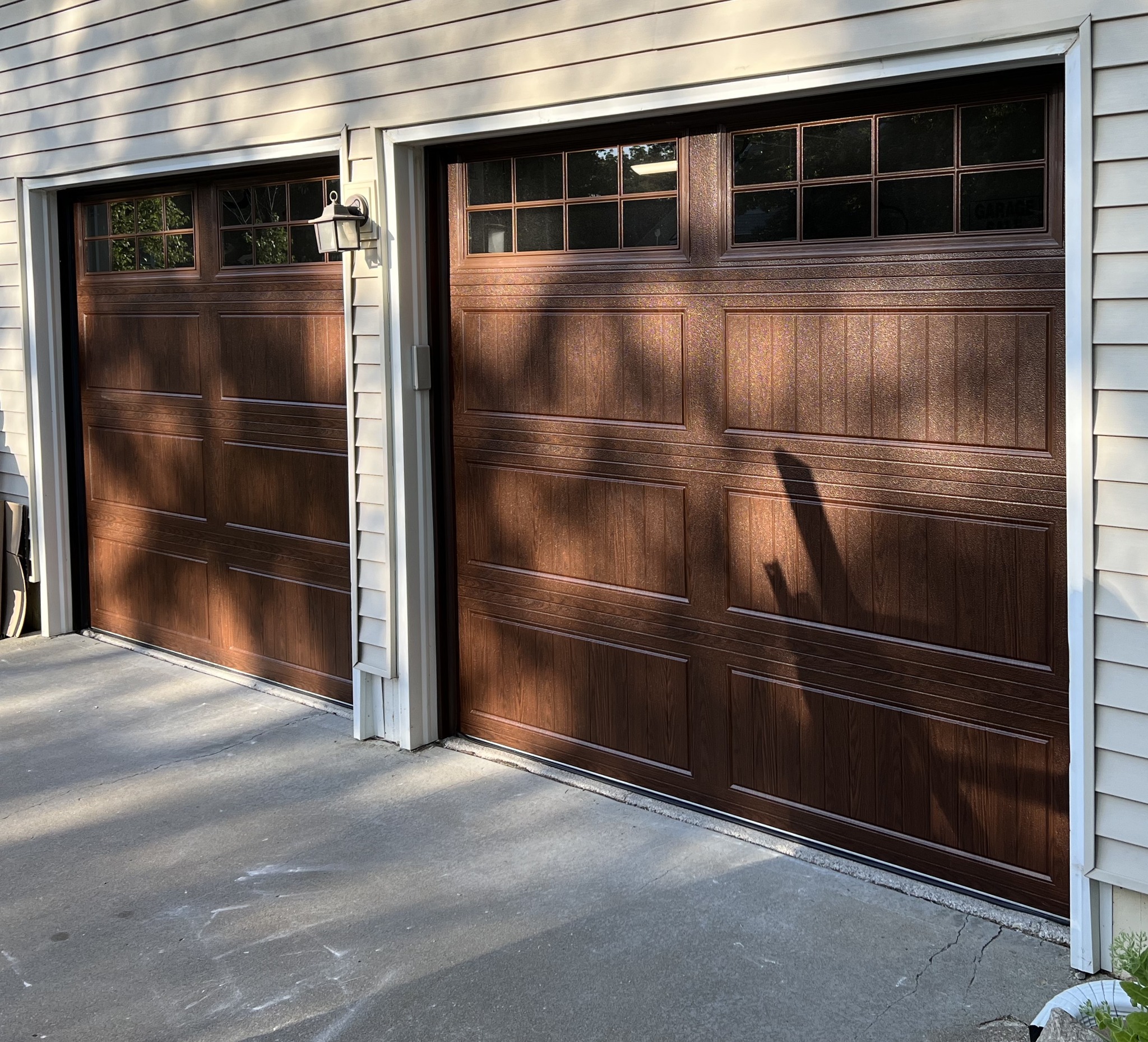 2 DoorLink 3640 steel garage doors in Walnut. Long panel glass in top section with Stockton inserts.