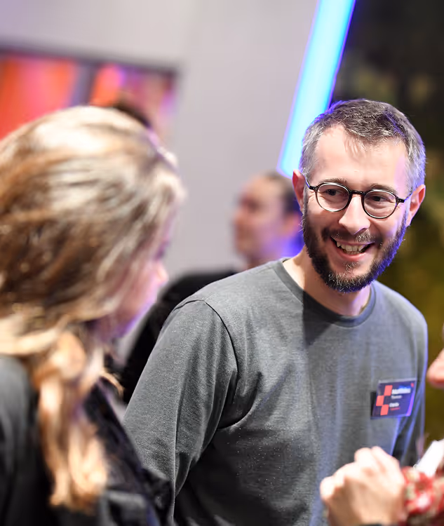 Jeune homme discutant avec une autre personne lors d'un événement convivial
