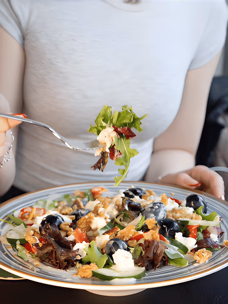 Frau isst gesunden und leckeren Salat von Restaurant MUG&MUSE