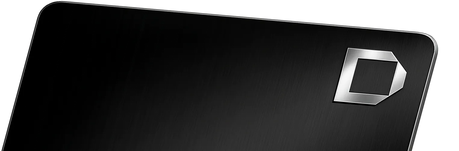 Close-up of a black metal surface corner with a silver geometric logo.