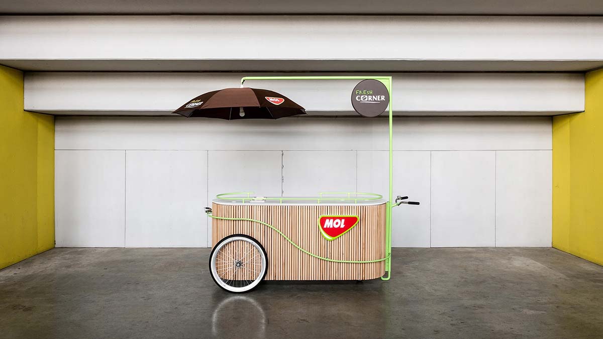 Mobile vendor stand for MOL Fresh Corner, built around a steel structure enveloped in beech baguettes and covered with a solid surface material countertop.
