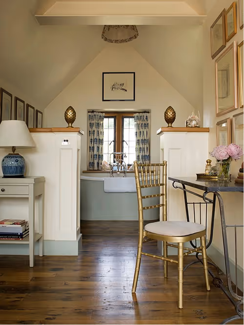 Outdoor tennis court surrounded by trees and bushes on a sunny day with a partly cloudy sky.