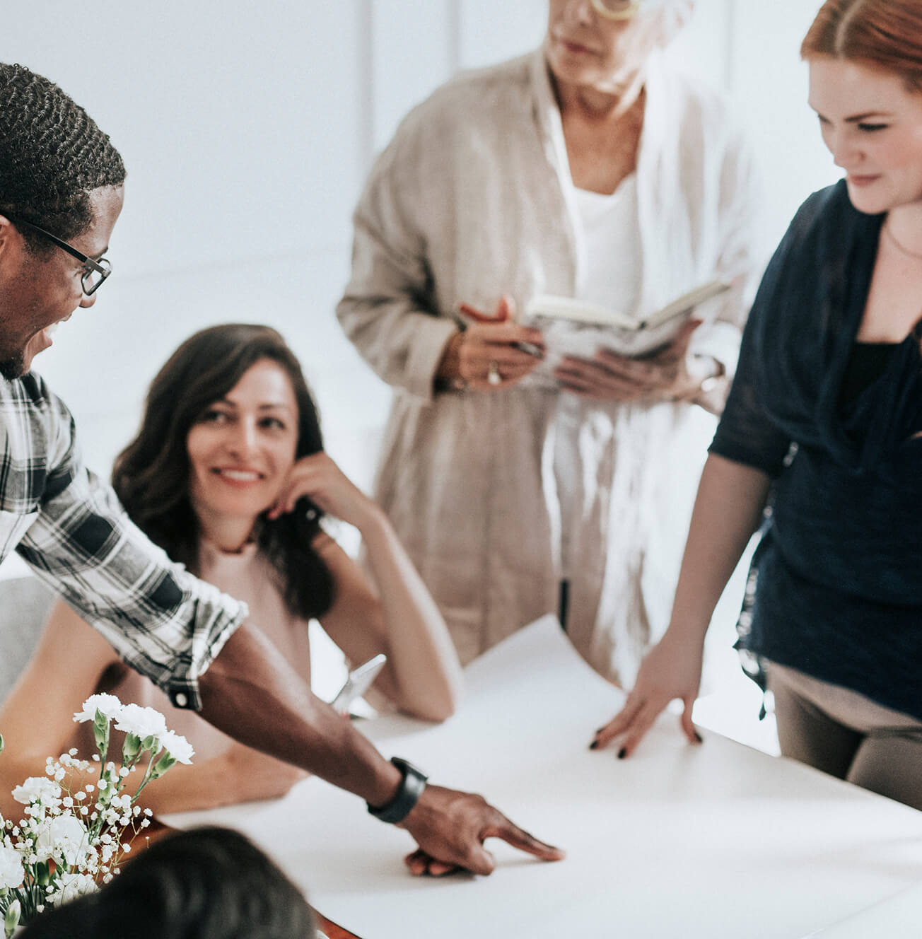Four people gather around a table for a discussion