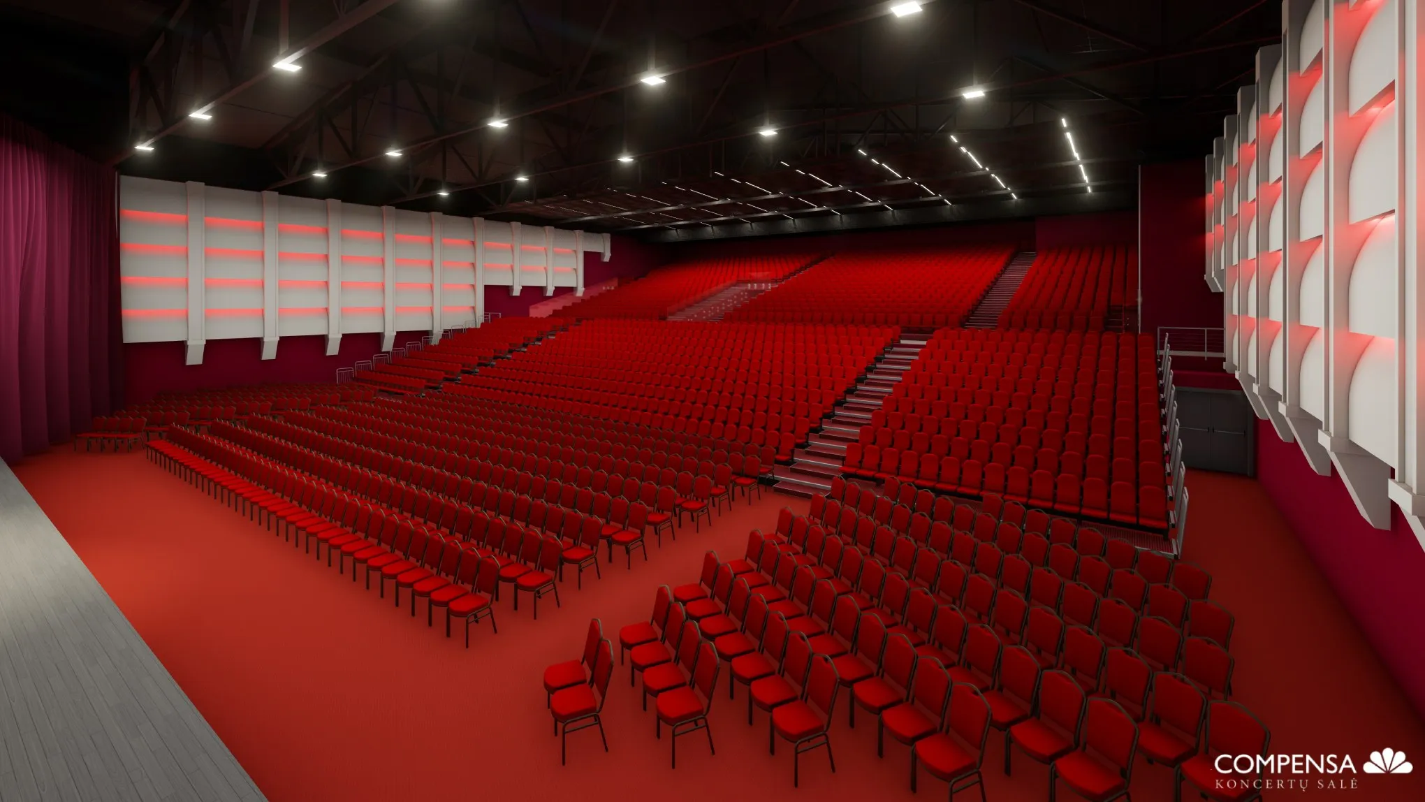 Large auditorium with rows of red chairs facing a stage, modern lighting and wall decor.