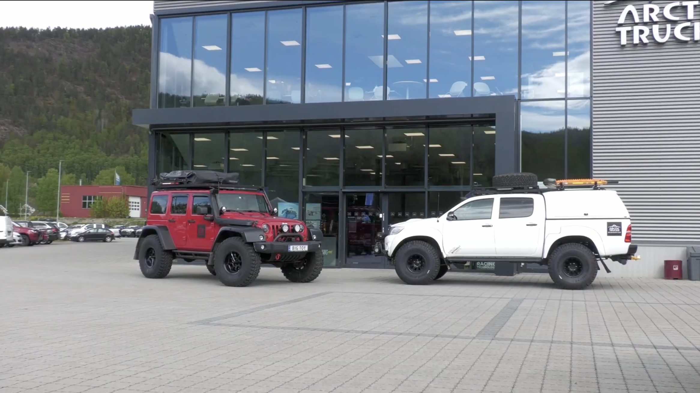Eksteriørbilde av Artic Truck sitt varehus med to av deres spesialbygde biler