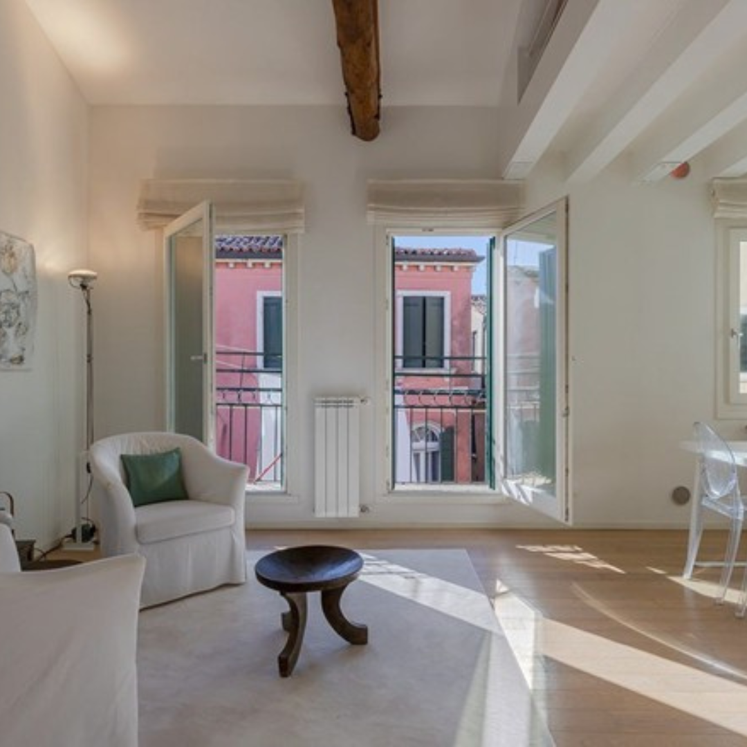 Raum mit Sitzecke und grossen offenen Fenstern