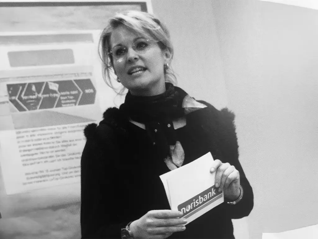 Nicole Flockenhaus führt einen Leadership-Workshop vor einer Gruppe von Führungskräften, auf der Leinwand steht Leadership Kompetenz.