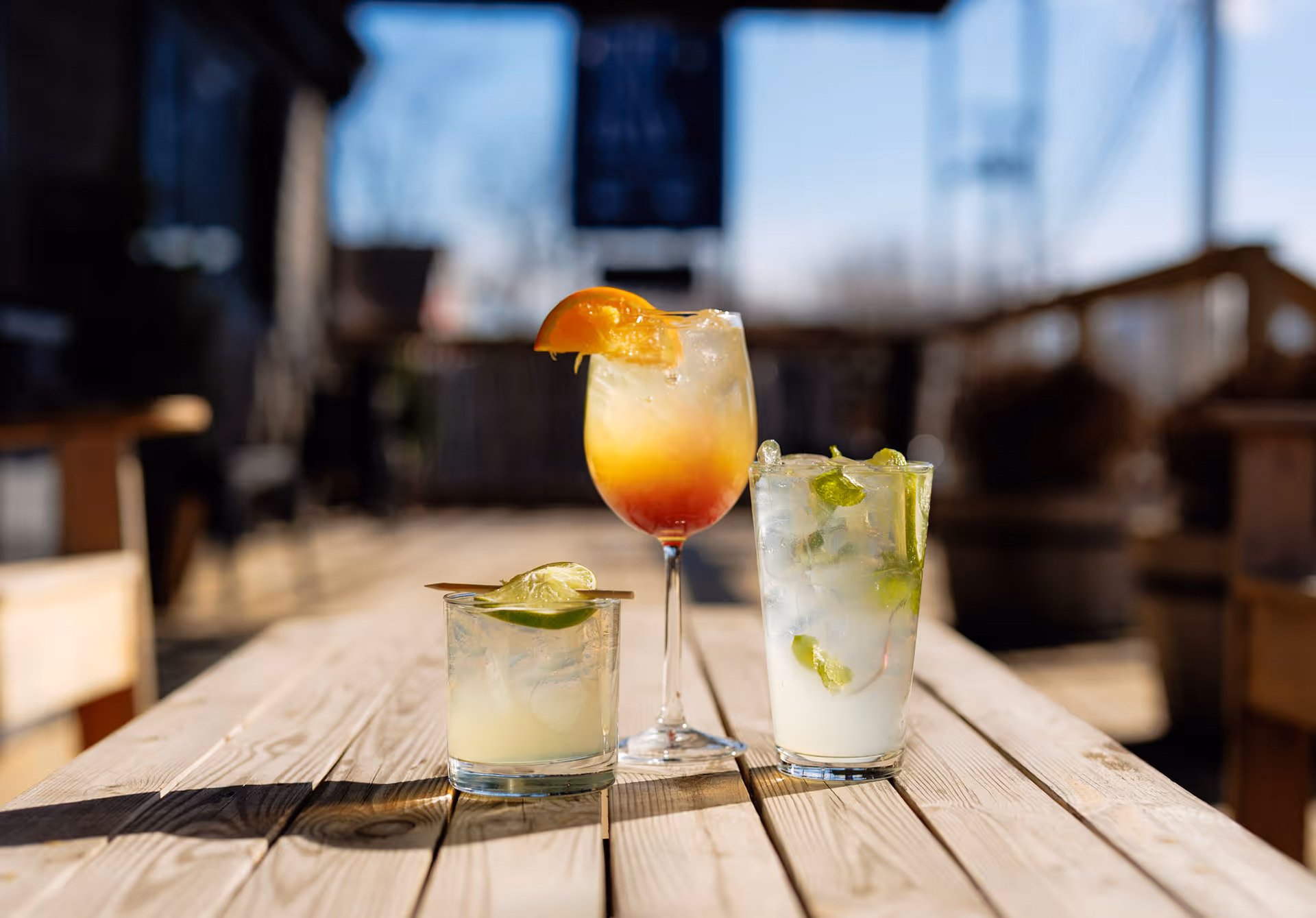 Handcrafted cocktails on a wooden picnic table