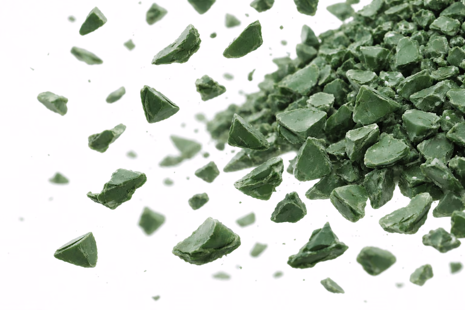 Close-up of small, irregular green shards scattered on a white background.