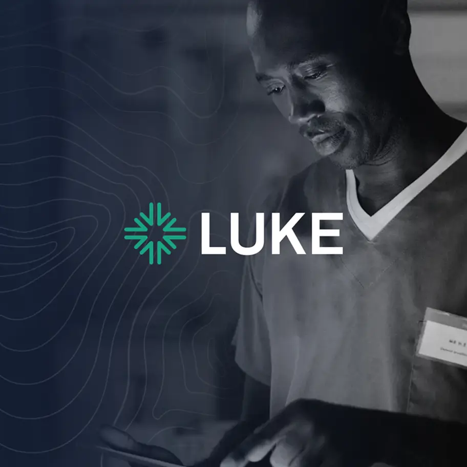 Healthcare professional in scrubs looking at a tablet with LUKE logo overlayed.