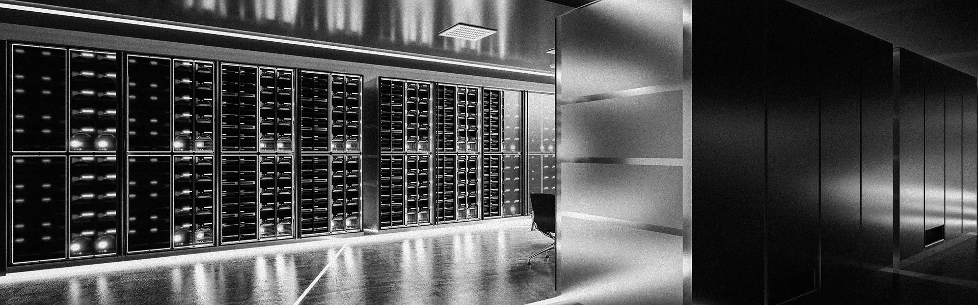 Modern data center interior with rows of illuminated server racks and a partially visible office chair.