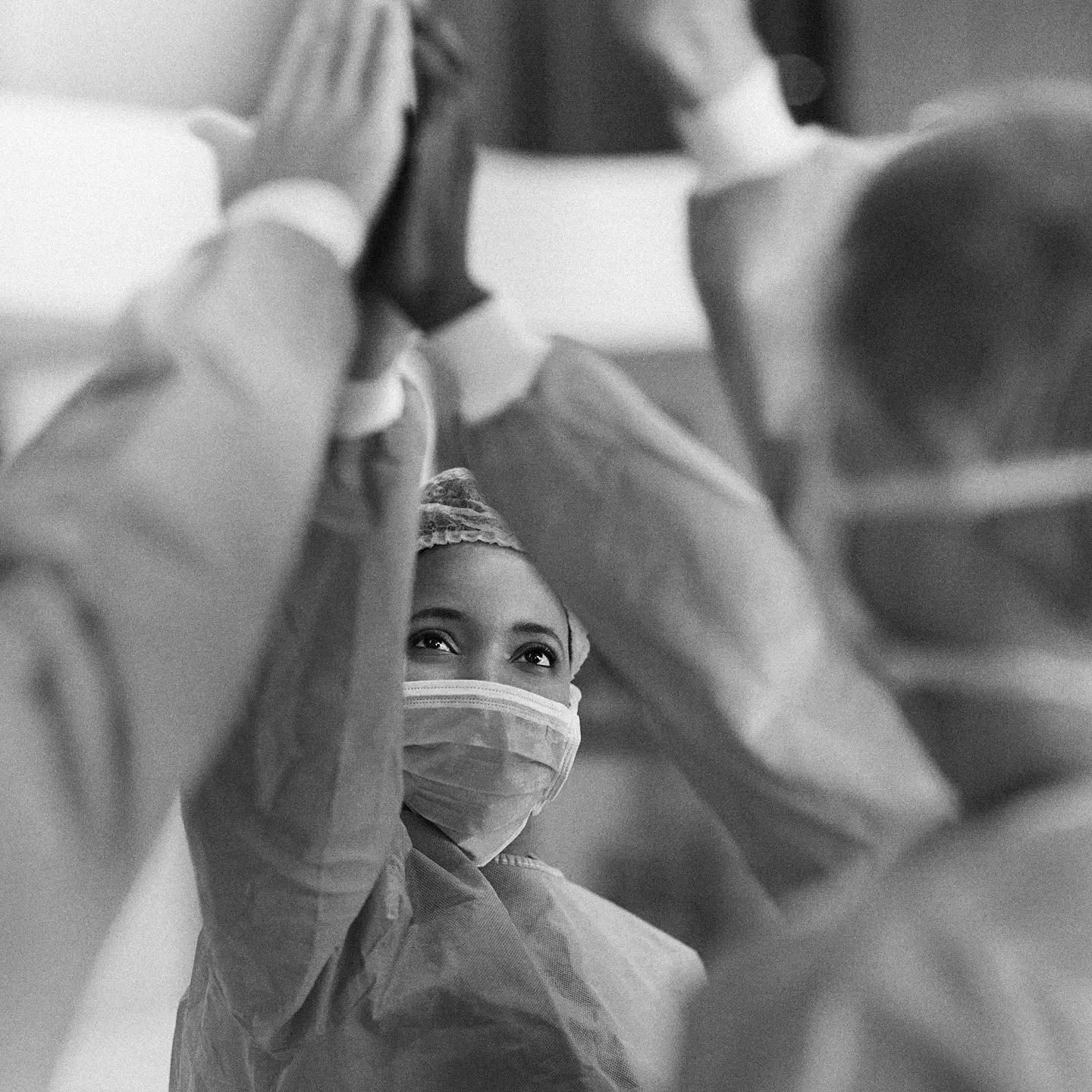 Healthcare workers in protective gear giving a group high-five.