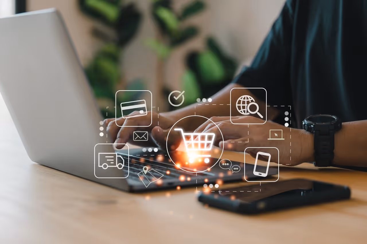 Person tippt auf einem Laptop mit überlagerten Symbolen für Online-Shopping, Kreditkarte, Lieferung und Internetsuche.