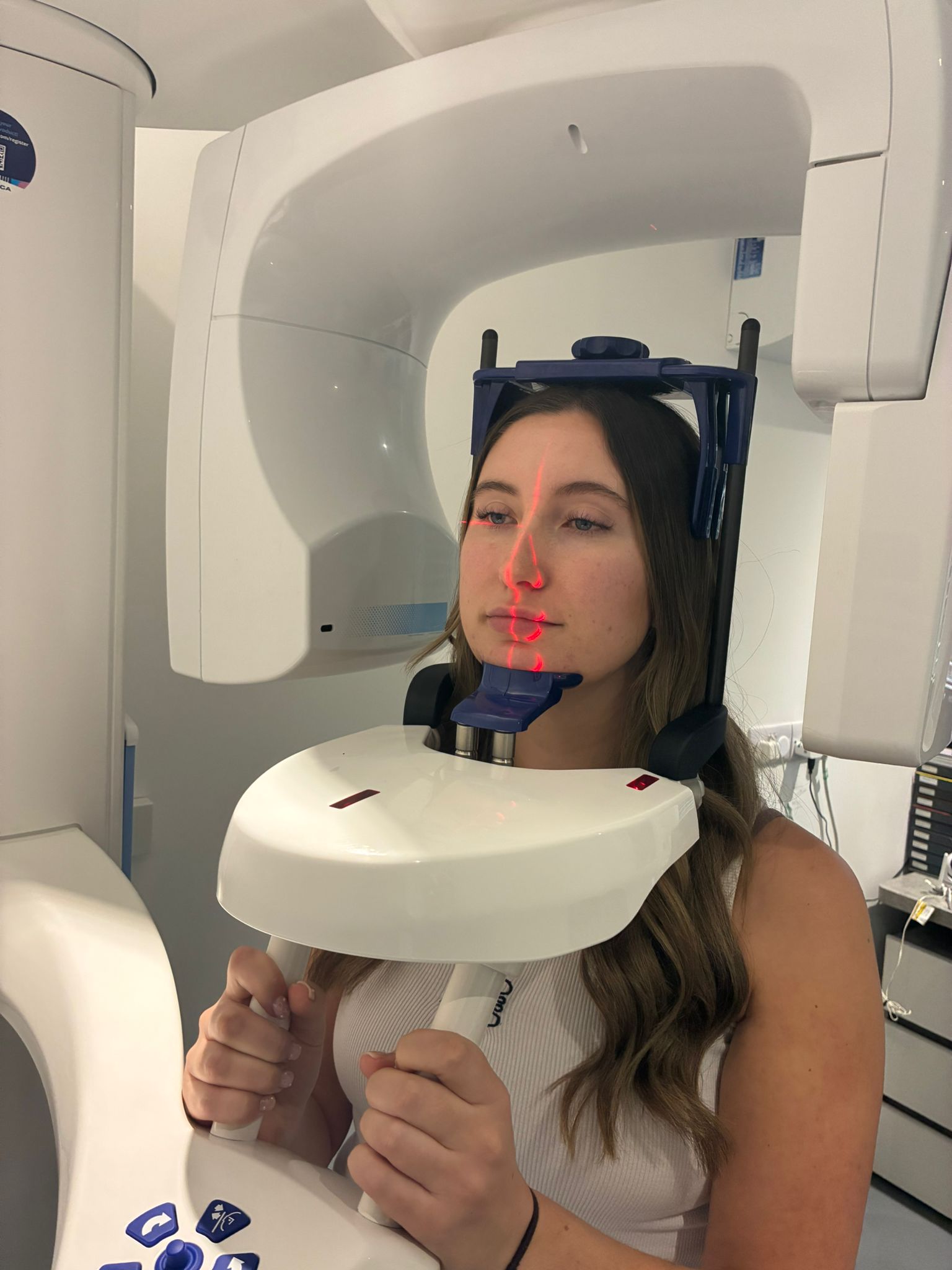 Young woman undergoing a 3D dental X-ray scan with a panoramic dental imaging machine.