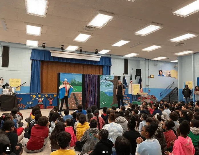 Students watching a live theatrical performance in school auditorium