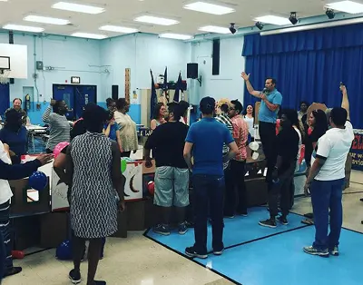 Adults participating in a group activity in school gymnasium