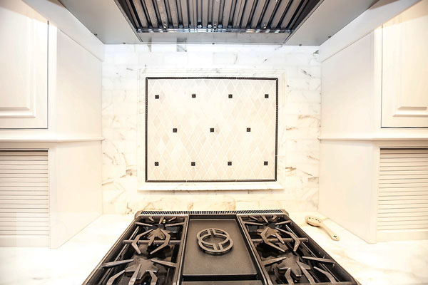 Marble backsplash with metal accents in the traditional Norwell kitchen