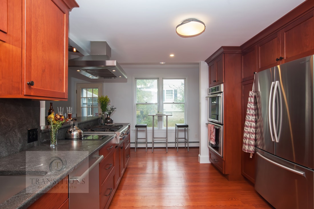 Cherry wood cabinetry detail with dark gray countertops in the Weymouth kitchen