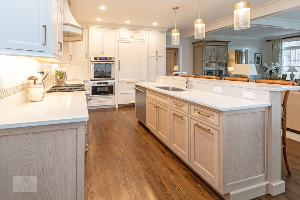 Light wood beaded inset Mouser lower cabinets with white uppers in the Cohasset kitchen